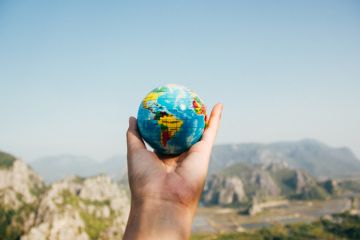 Personne Tenant Le Globe Terrestre Face à La Montagne